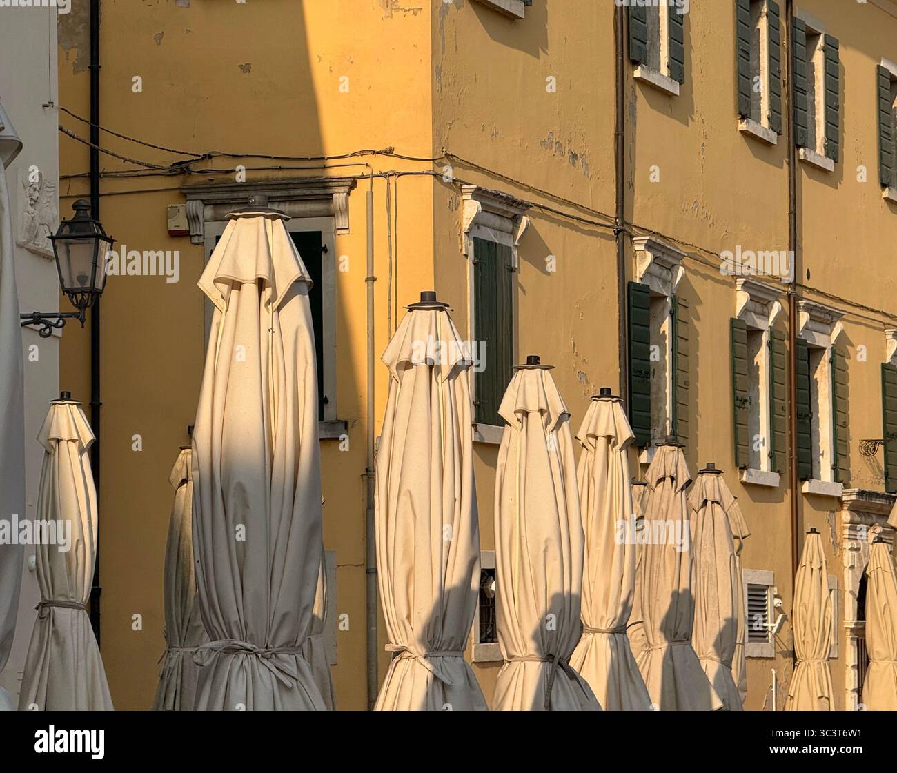 Tied up canopies early morning in the main square at Lazise on Lake Garda, Italy - Smartphone Captured Stock Image