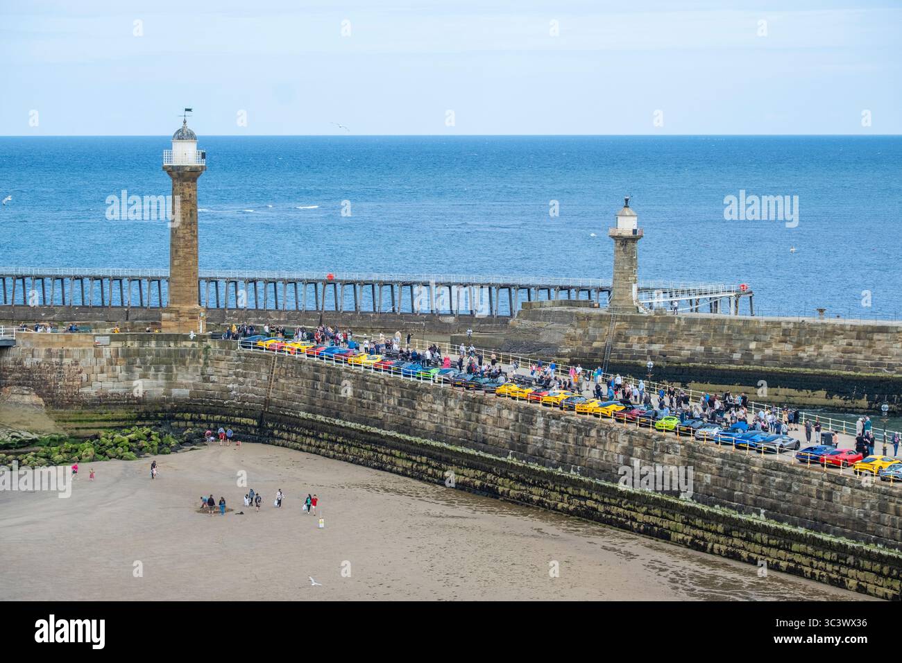 Whitby, North Yorkshire, England. UK. 27th July, 2025. Bright and breezy with a cool brisk wind on Whitby beach on the Yorkshire coast. PICTURED: A colllection of Lotus cars on Whitby pier in aid of RNLI donations. Credit: Alan Dawson/Alamy Live News Stock Photo