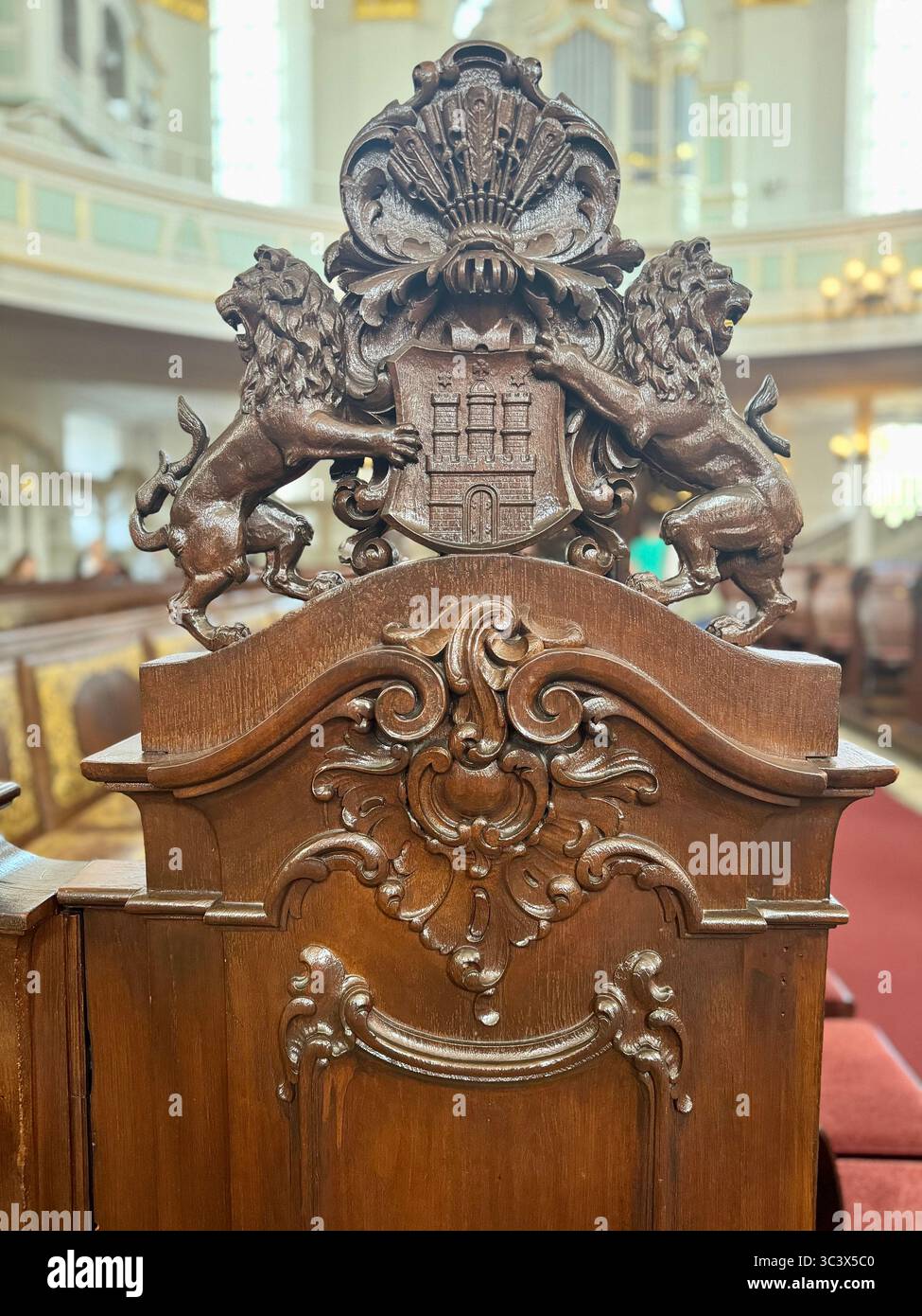 Ornate wooden chair backrest with carved lions and a coat of arms detail inside St. Michael's Church, Hamburg, Germany. - Smartphone Captured Stock Image