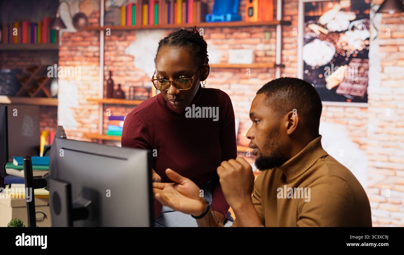 Teamworking programmers creating deep learning models analyzing data in artificial intelligence development agency. African american IT coworkers programming in AI startup office, camera B Stock Photo
