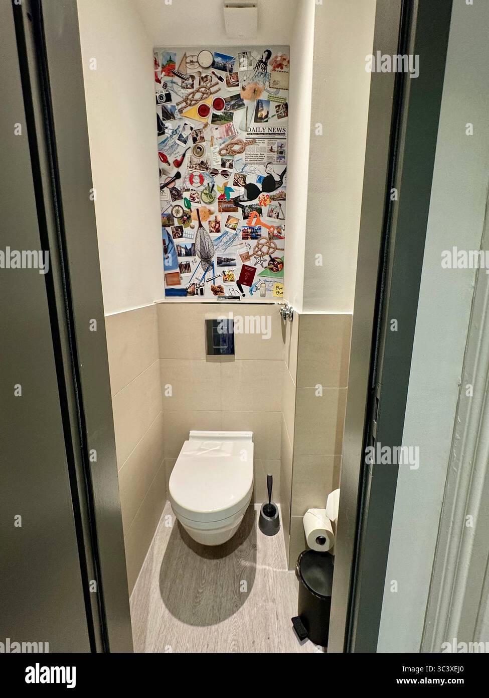 Modern hotel toilet with creative collage wall art at the NIU Hotel in Germany, featuring a minimalist and stylish interior design. - Smartphone Captured Stock Image