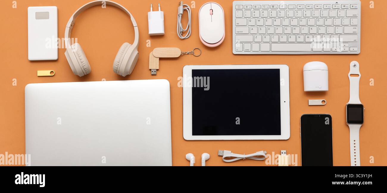 Many different modern gadgets on orange background Stock Photo