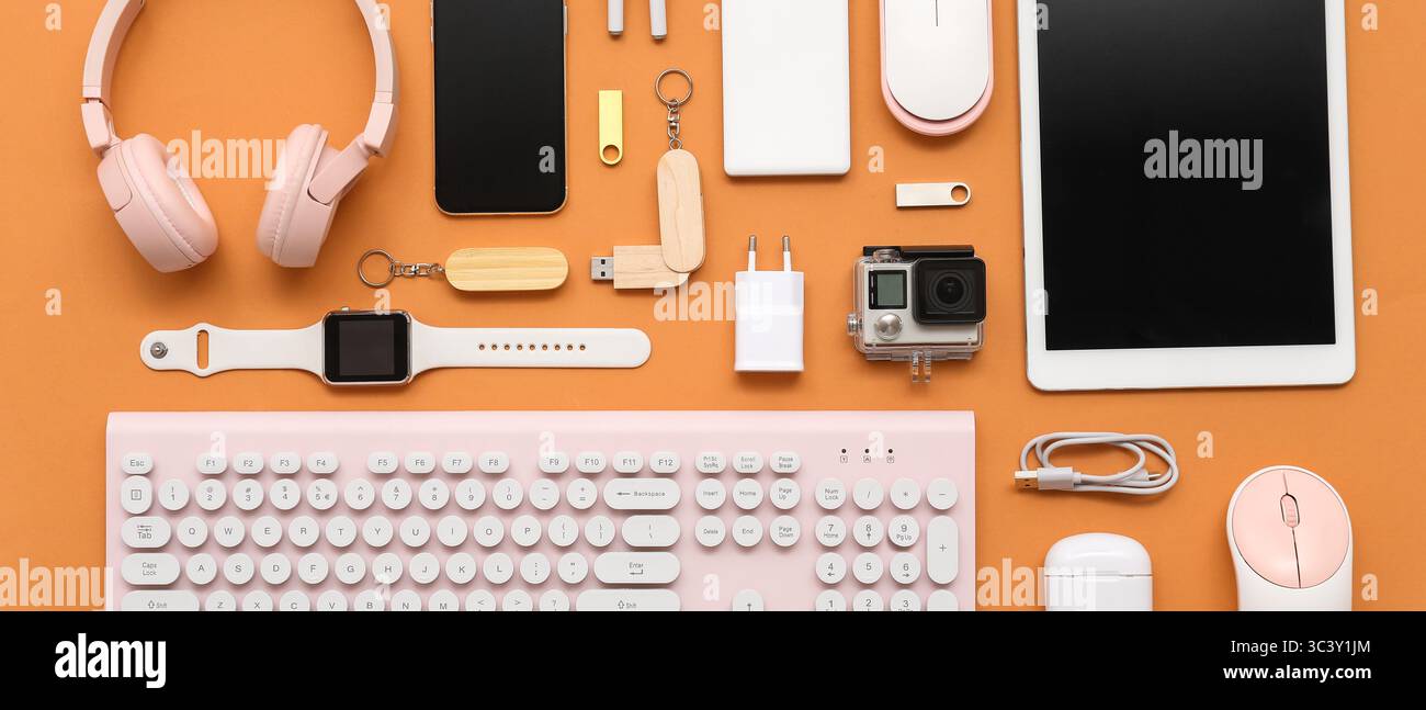 Many different modern gadgets on orange background Stock Photo