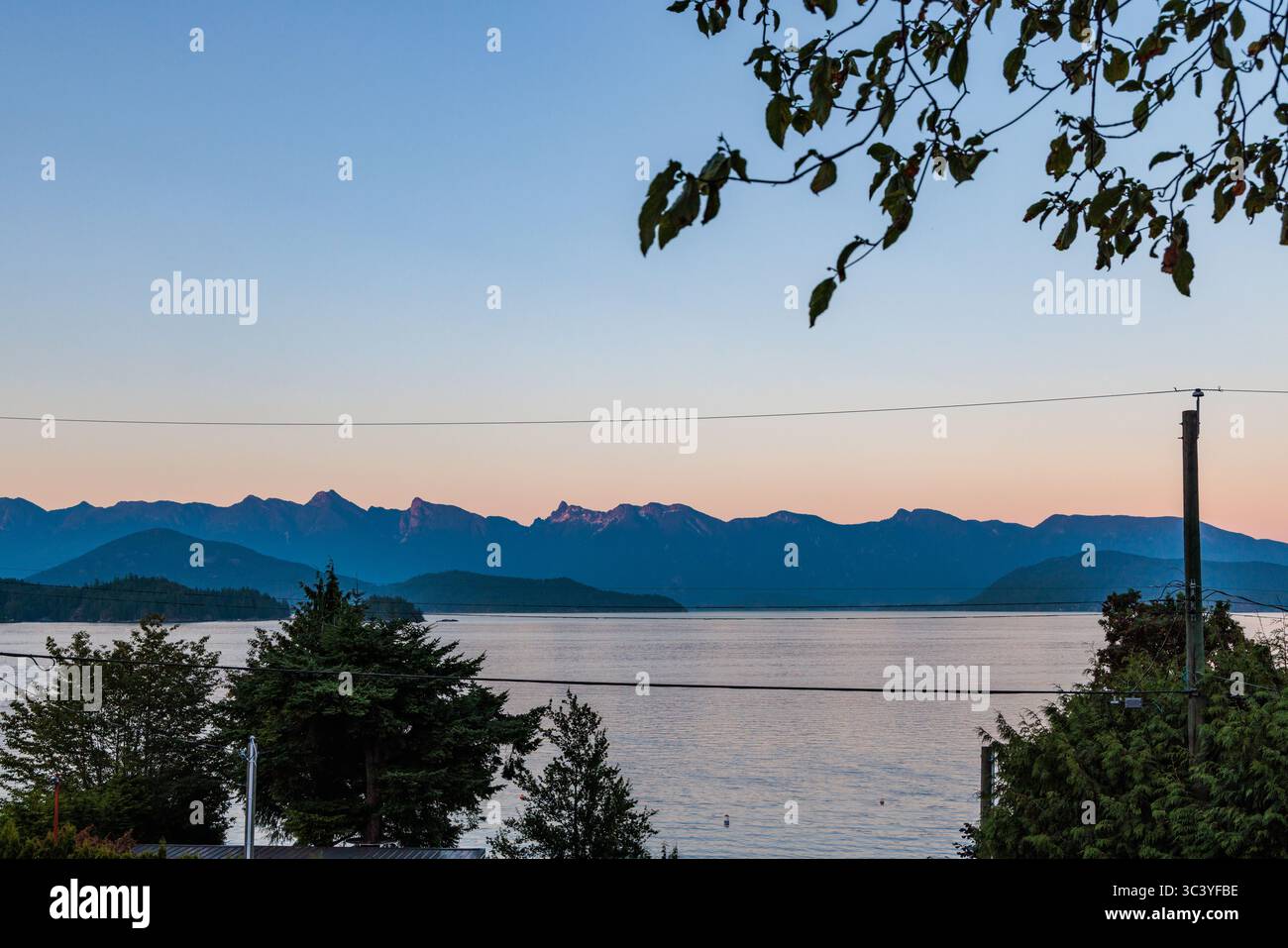 Sunset view of the North Shore mountains in Vancouver, Canada, from Gibsons, across the water. Stock Photo