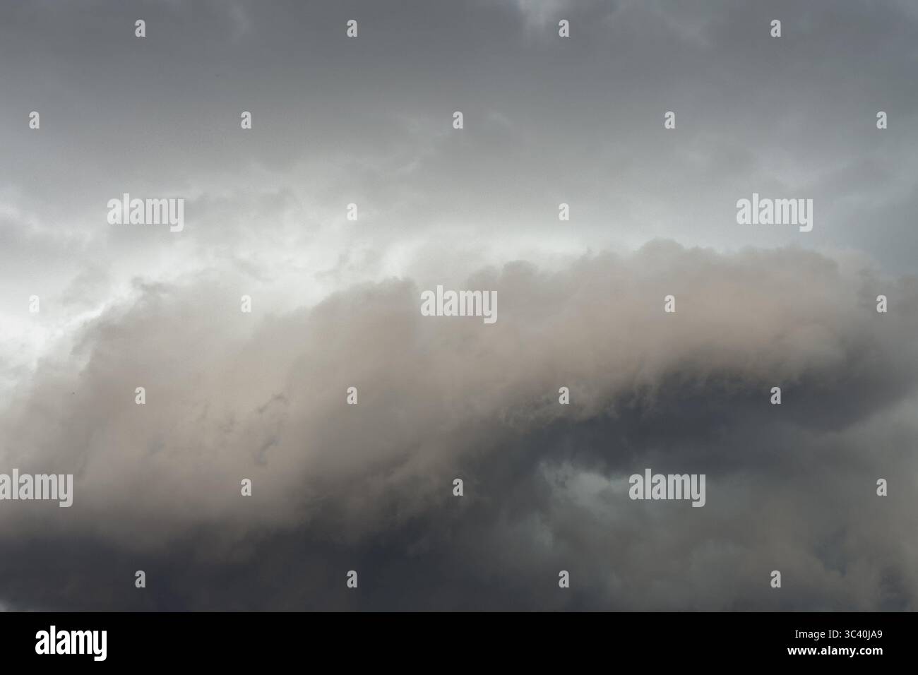 Below dark discoloured storm clouds Cloud roll above grey clouds Rain clouds heralding thunderstorms, Germany Stock Photo