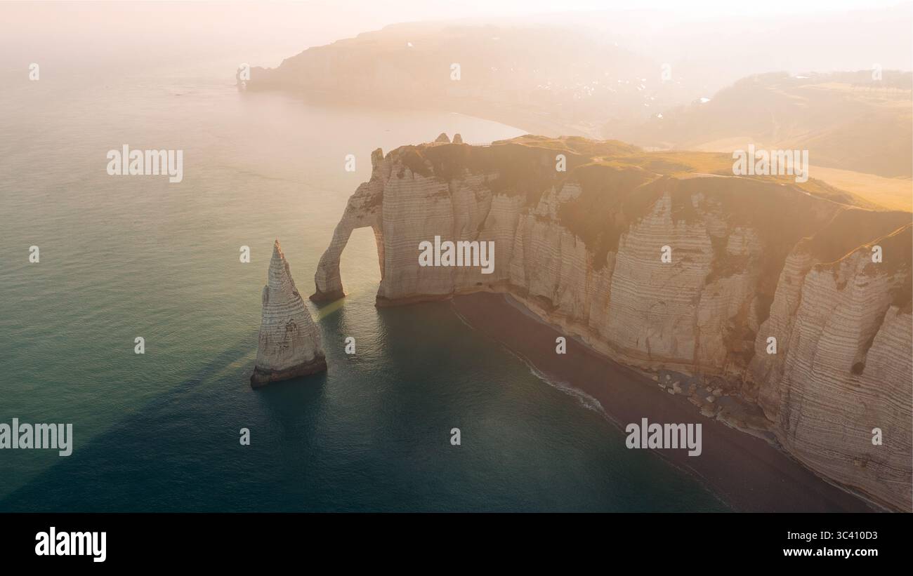 Aerial view of the dramatic cliffs of Etretat meeting the sea under a ...