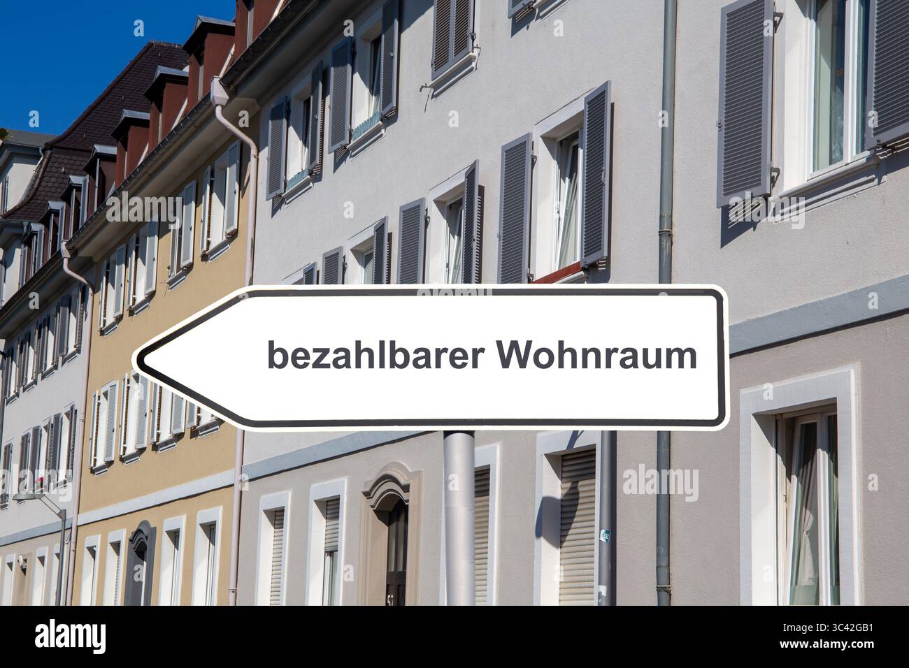 (Photomontage) Sign with the words BEZAHLBARER WOHNRAUM in front of municipal apartment buildings Stock Photo