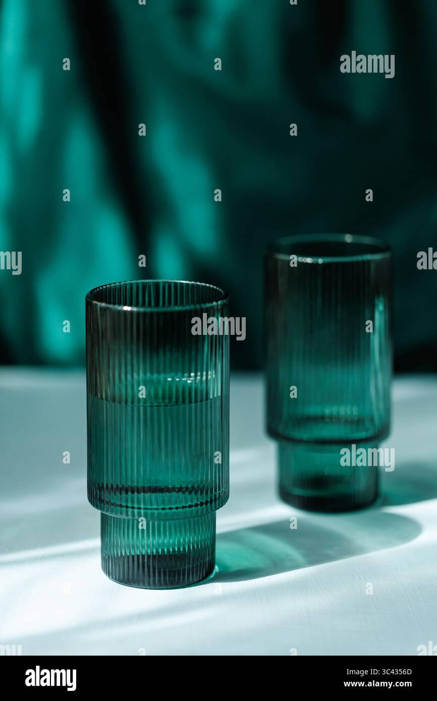 Dual Transparent Ribbed Glasses on White Table Stock Photo
