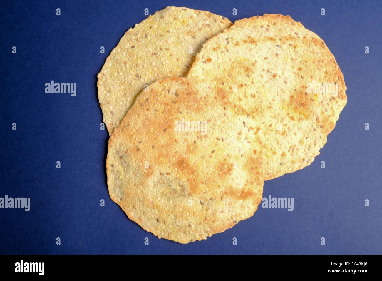 Flatbread crackers with seeds on a blue background Stock Photo