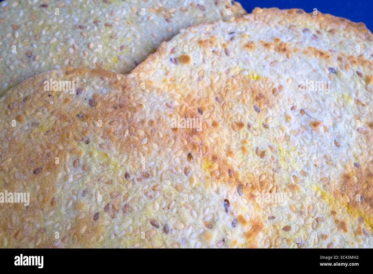 Flatbread crackers with seeds on a blue background Stock Photo