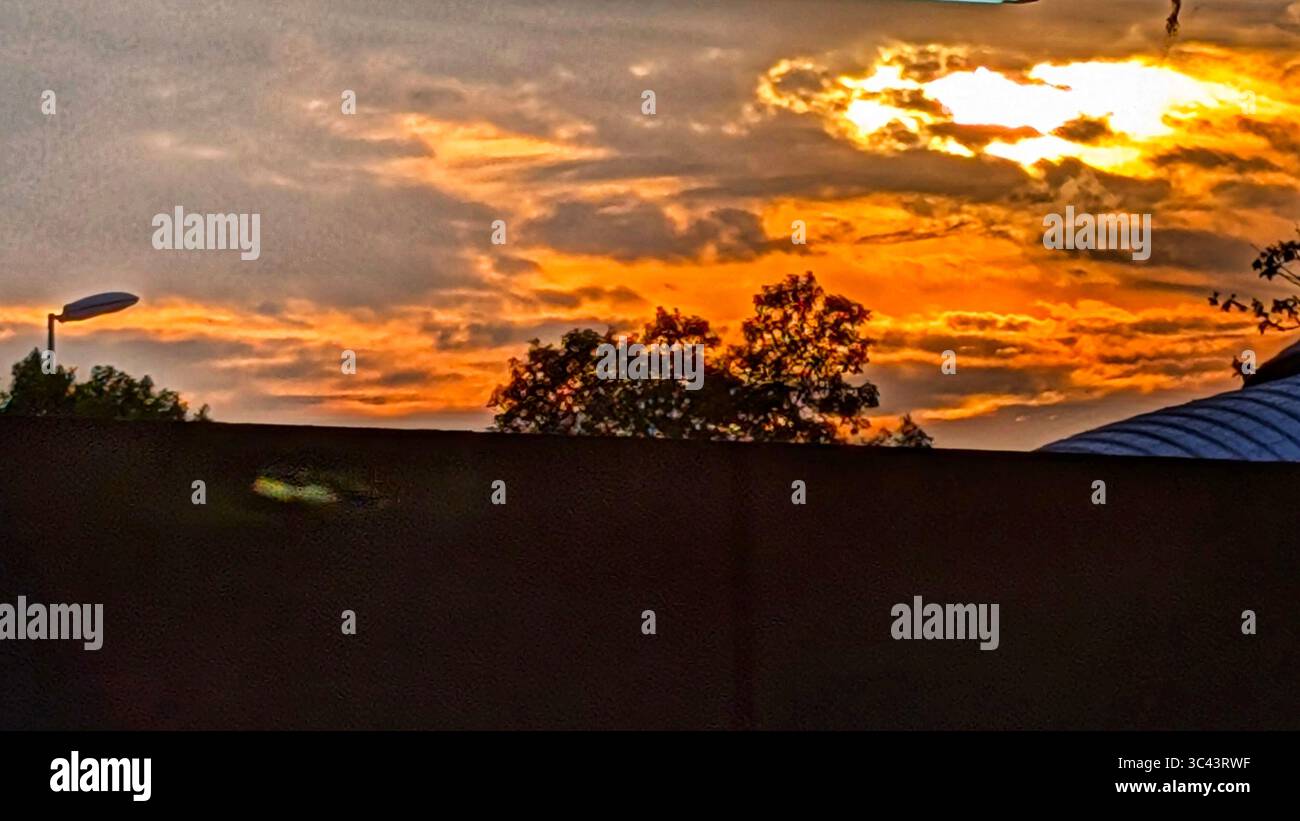 breathtaking sunset photography scene unfolds at Batu Caves Malaysia, where a golden hour sky meets urban tower lights and road night lighting. From - Smartphone Captured Stock Image