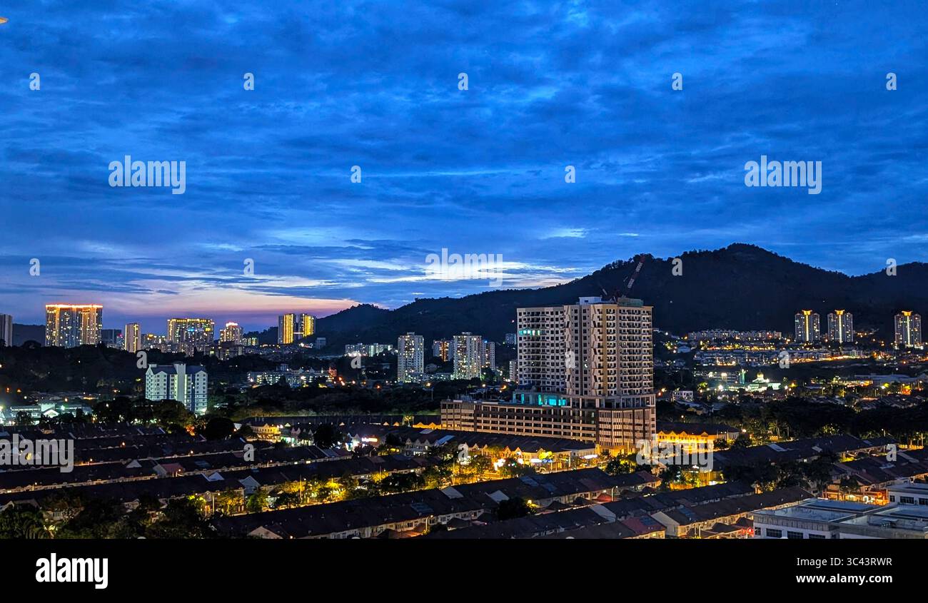breathtaking sunset photography scene unfolds at Batu Caves Malaysia, where a golden hour sky meets urban tower lights and road night lighting. From - Smartphone Captured Stock Image