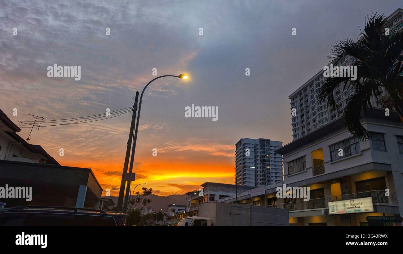 breathtaking sunset photography scene unfolds at Batu Caves Malaysia, where a golden hour sky meets urban tower lights and road night lighting. From - Smartphone Captured Stock Image