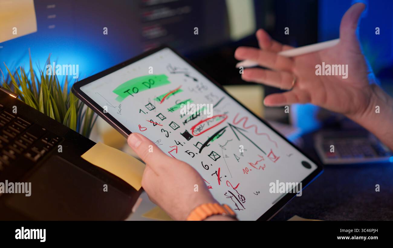 graphic tablet Project Chaos Frustration To Do List Overload visualized by messy notes on digital tablet. Developer reacting to excessive corrections, Stock Photo