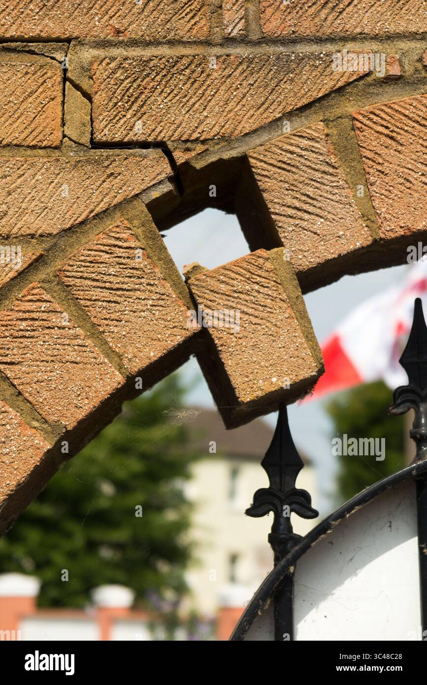 Brick falling from arch in wall which could lead to collapse. Caused by ...