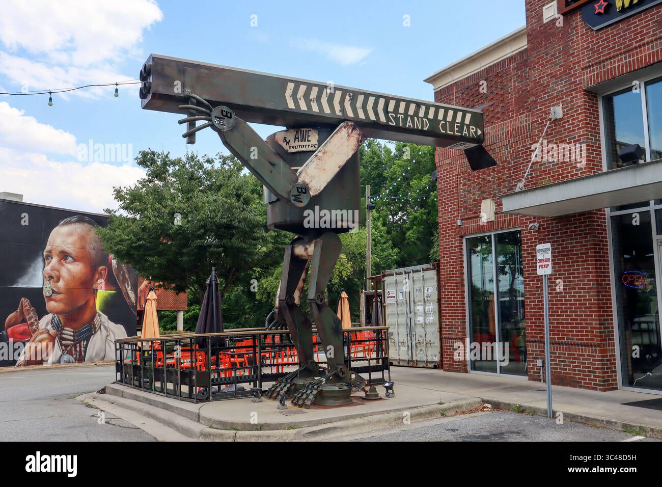In Greensboro, NC, a towering Burger Robot with a plasma cannon guards a local burger joint with sci-fi flair and tongue-in-cheek humor. Stock Photo