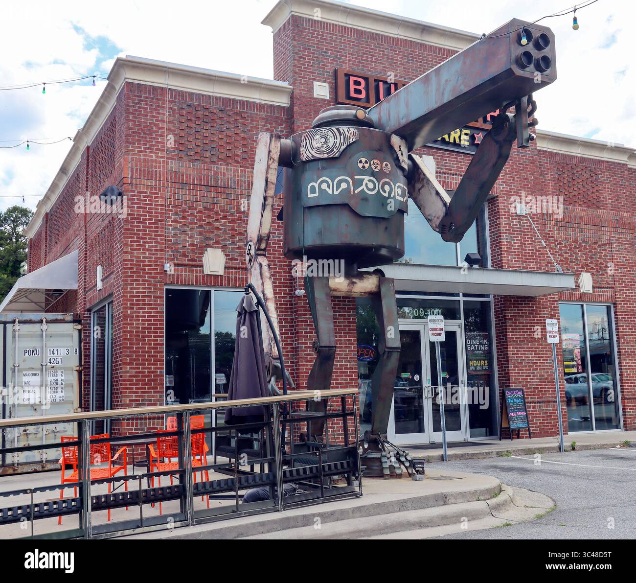 In Greensboro, NC, a towering Burger Robot with a plasma cannon guards a local burger joint with sci-fi flair and tongue-in-cheek humor. Stock Photo