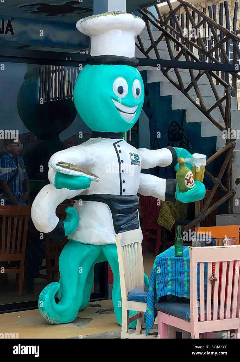 A cheerful octopus waiter statue greets diners outside a beachside restaurant in Progreso, Mexico — serving up seafood and cerveza with a smile! Stock Photo