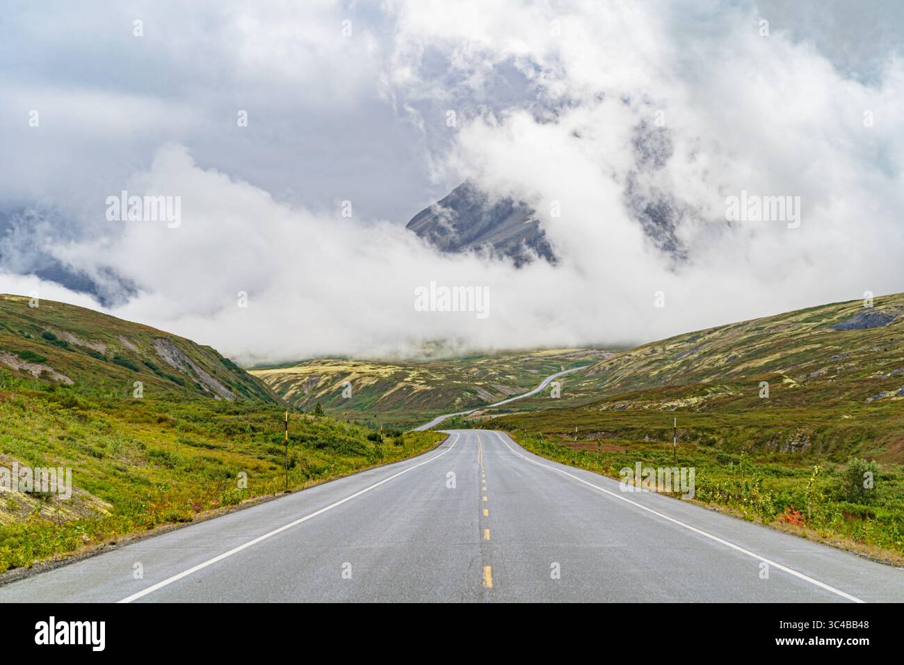 Highway to Cloud Mountain: Clouds shroud Mt. Seltat along the Haines Highway, creating a scenic, if somewhat obscured, view for travelers. Stock Photo