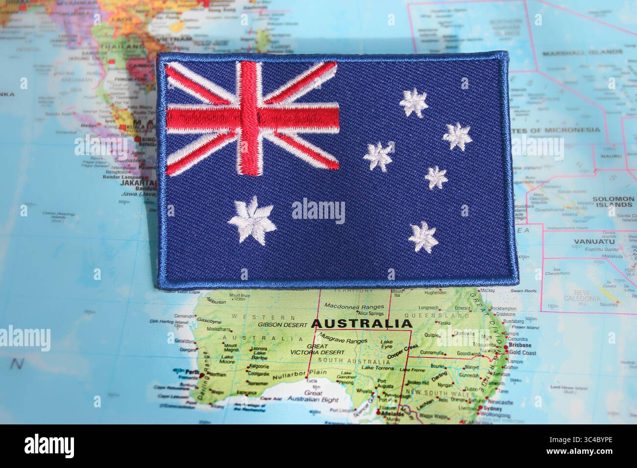 Eco-friendly Australia flag patch placed on a world map over Australia. Ideal for nature tourism, green travel, and global awareness visuals. Stock Photo