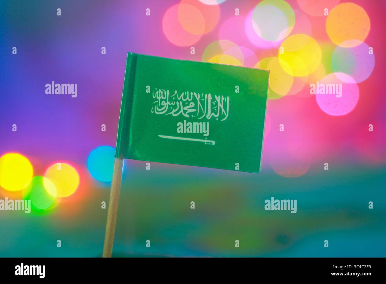 Colorful bokeh lights behind Saudi Arabian flag. Ideal for national celebration, Middle East identity & positive unity in modern visual storytelling. Stock Photo