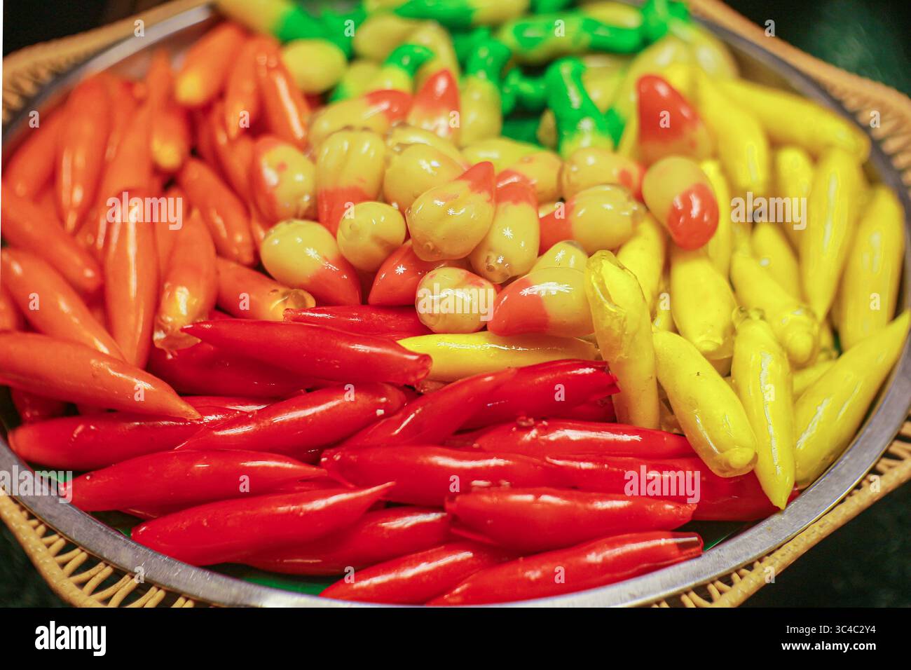 Luk Chup, Thai dessert made from mung beans, shaped into red chilies and yellow mangoes, glazed with gelatin. Street food favorite in Thailand. Stock Photo