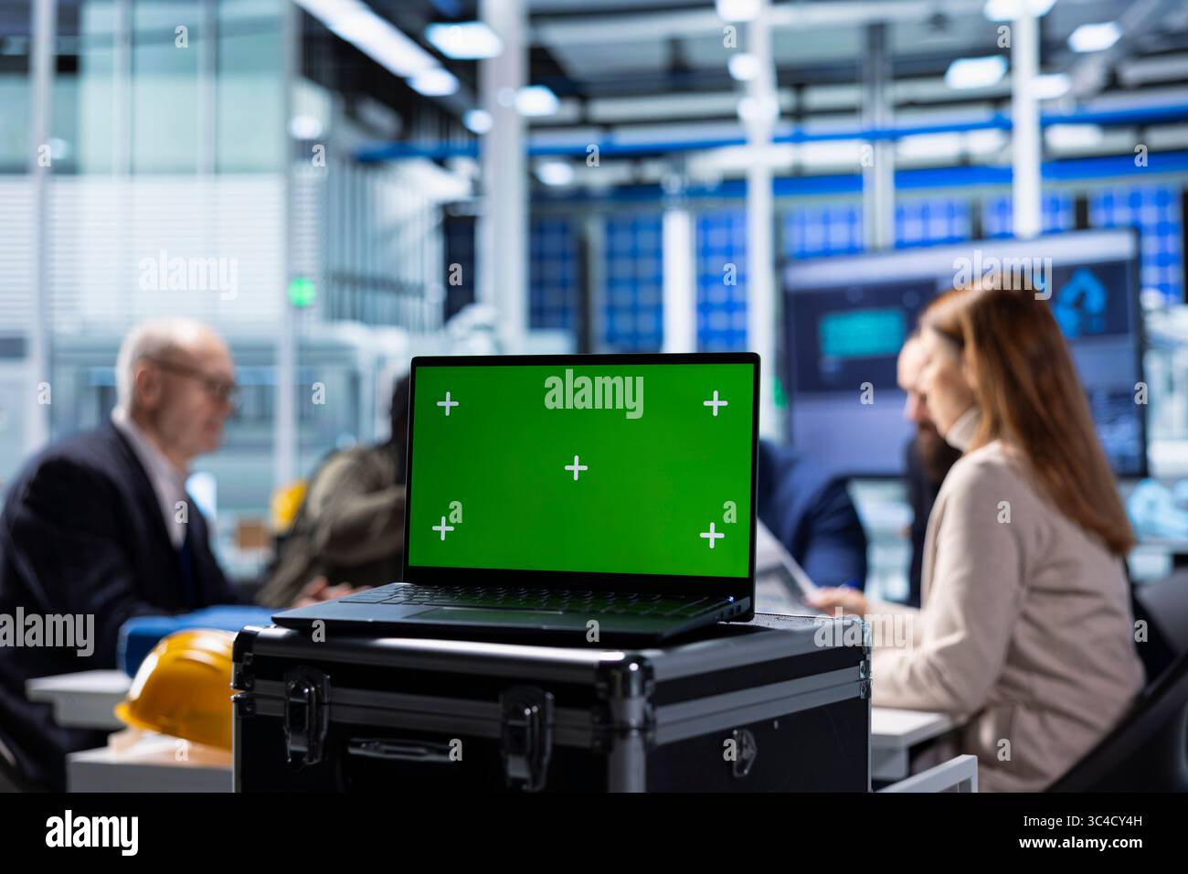 Investors evaluating factory production efficiency using green screen laptop before investing. Shareholders meeting with industrial plant managers to understand business model, using mockup notebook Stock Photo
