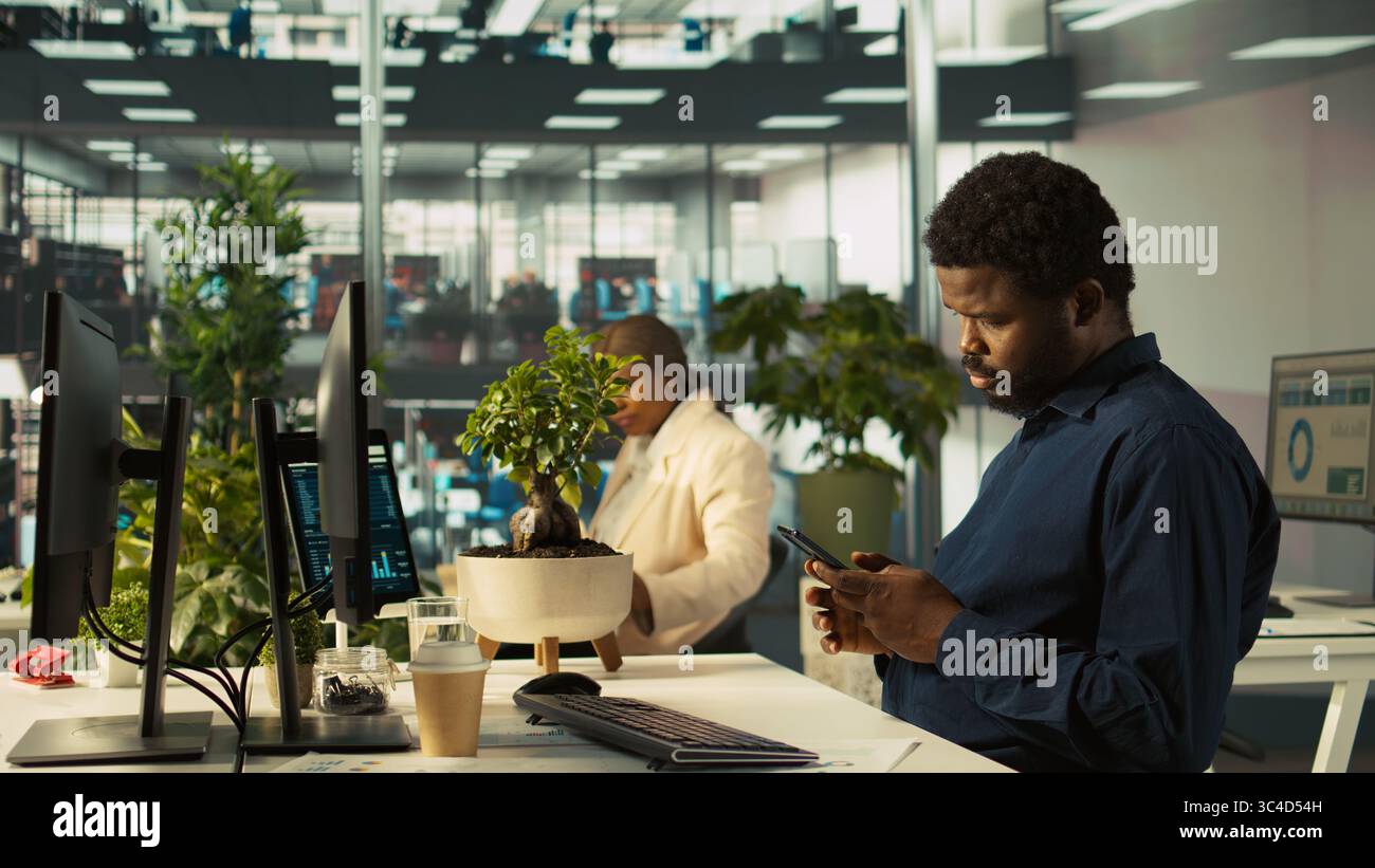 Accountant in modern office using mobile phone to text friends after ...