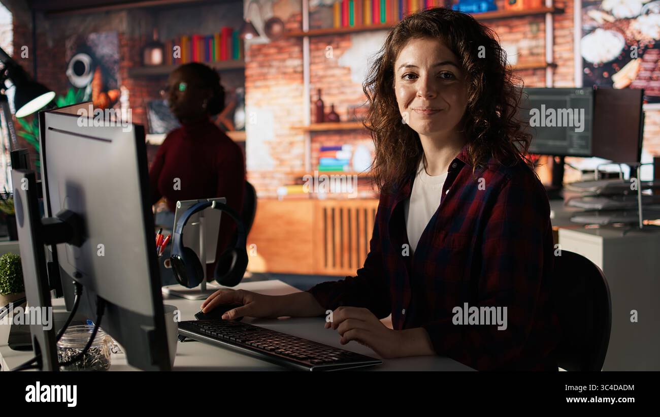 Portrait of upbeat programmer coding advanced AI algorithm in startup, refining machine learning models to enhance automation. Cheerful woman using coding platform in Silicon Valley office, camera A Stock Photo
