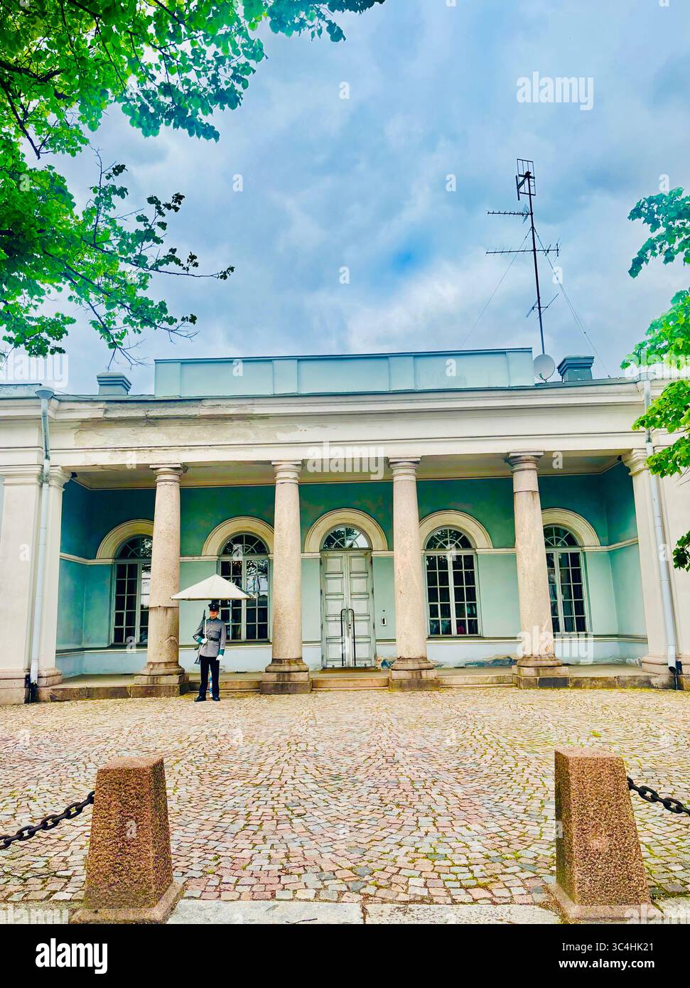 A guard standng outside the house of the Main Guard situated next to the Presidential Palace in Helsinki, Finland. - Smartphone Captured Stock Image