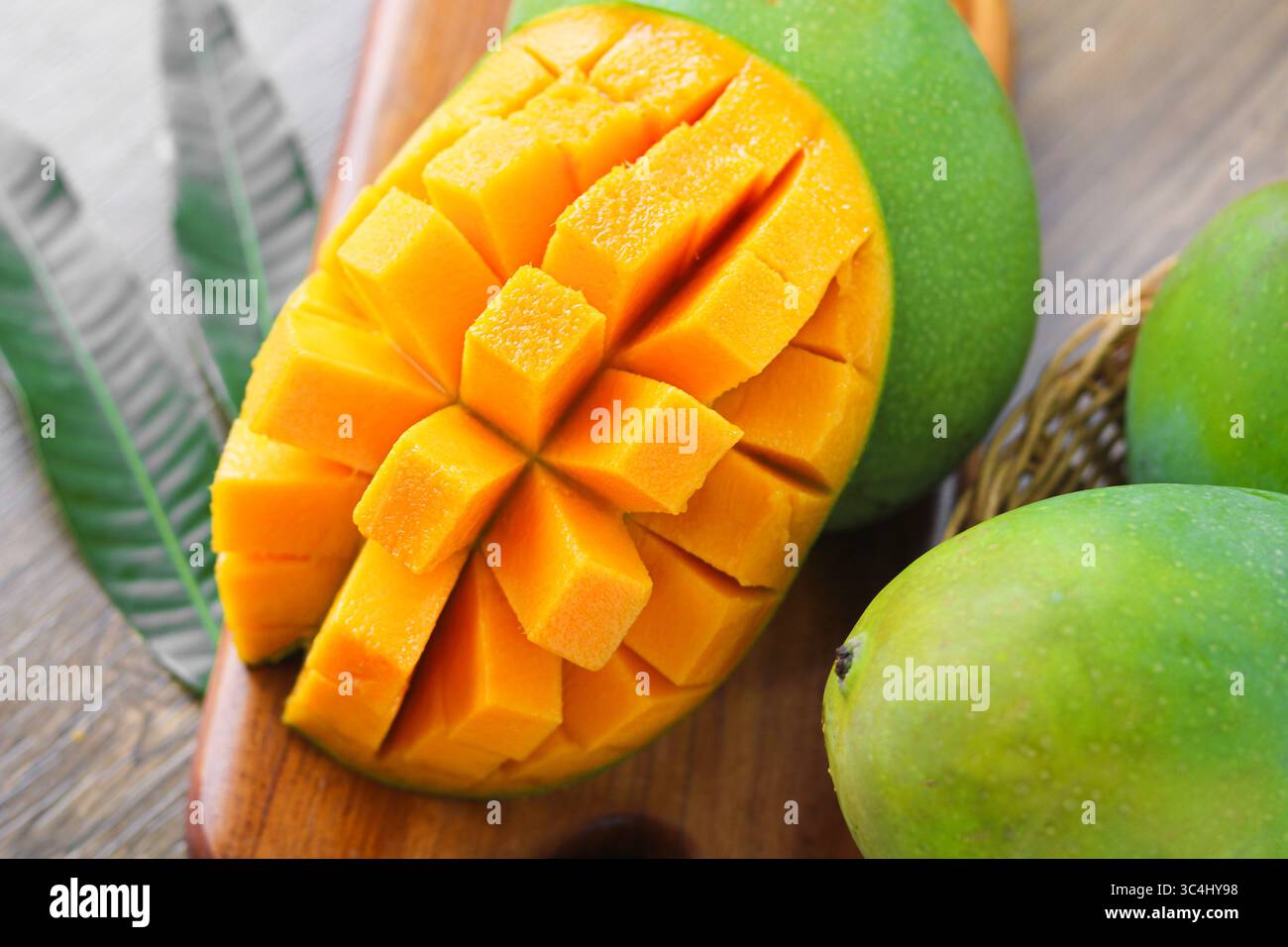 Closeup of a juicy ripe mango sliced in a grid pattern and partially ...