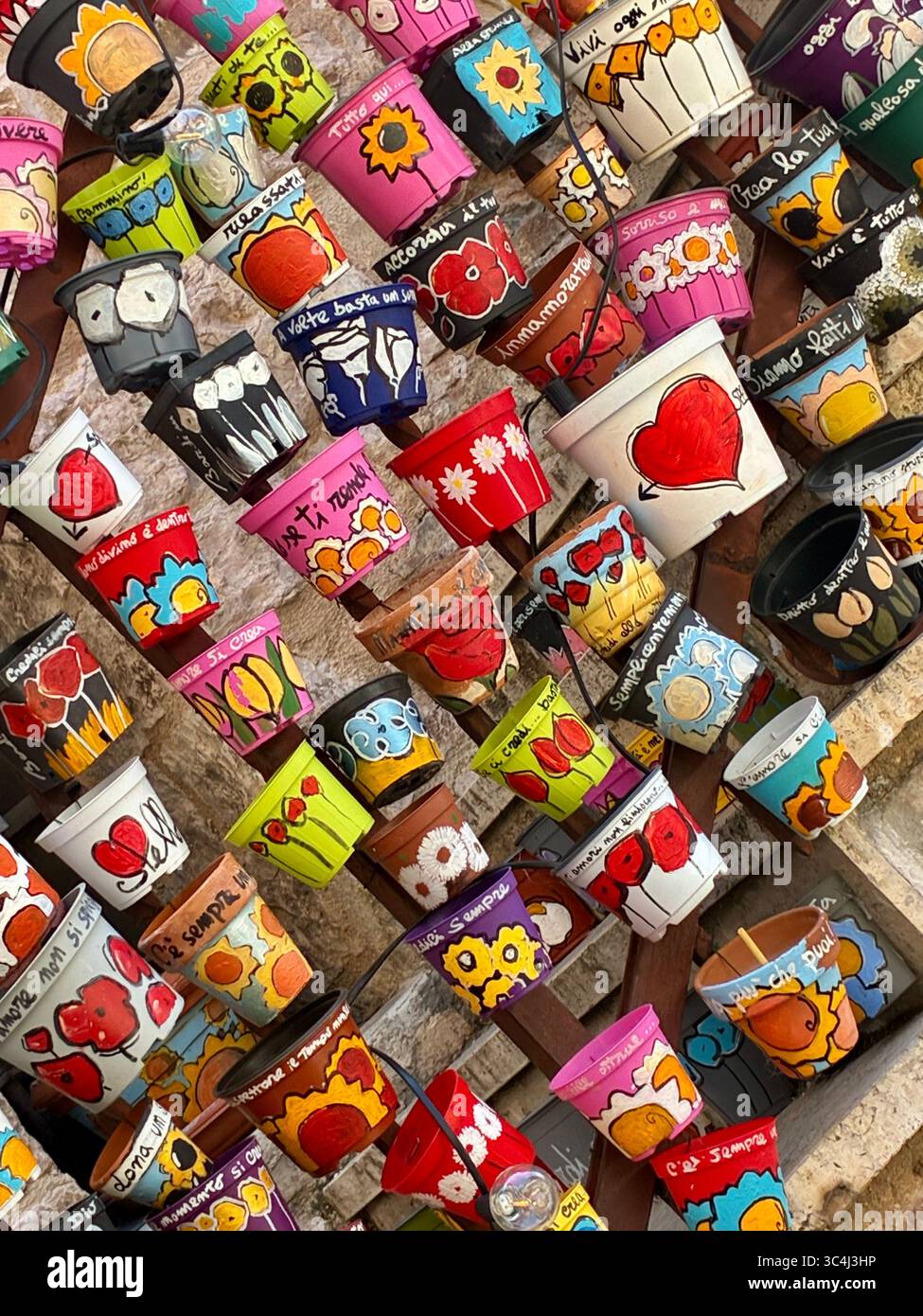 Not only do pottdn plants decorate the narrow streets of Spello in the Umbria region of Italy, there is also a display of painted pots - Smartphone Captured Stock Image