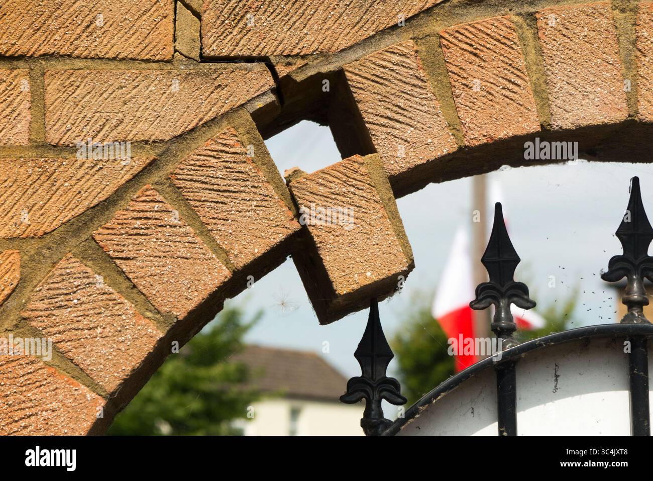 Brick falling from arch in wall which could lead to collapse. Caused by ...