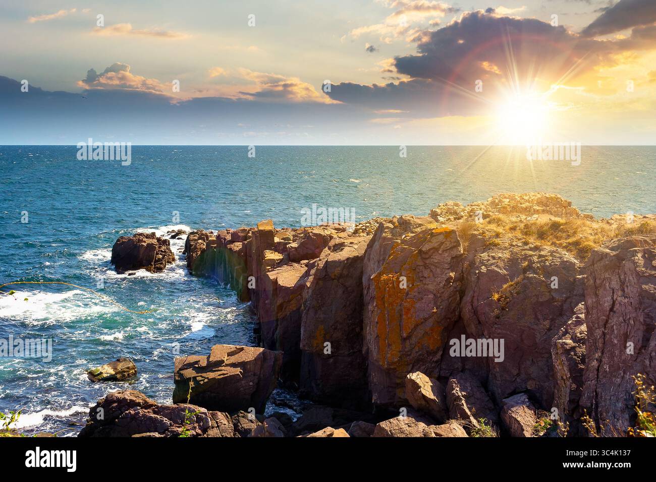 landscape with sea and coast with rock at sunset. vacation season with beautiful seascape in summer. travel background with water splash on stone in e Stock Photo