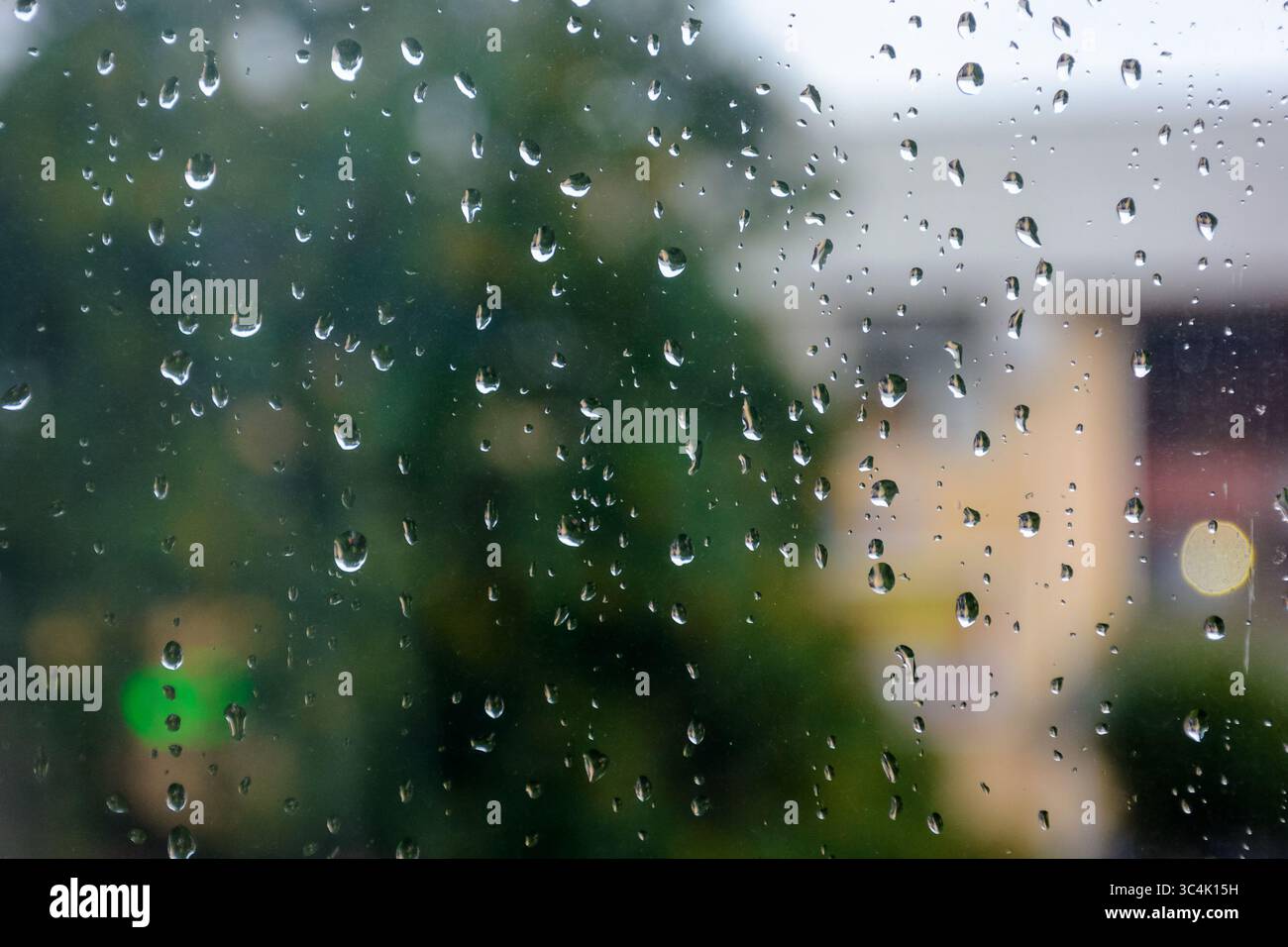wet window background. rain drop on the glass surface. bad weather concept. urban landscape blurred in the distance Stock Photo