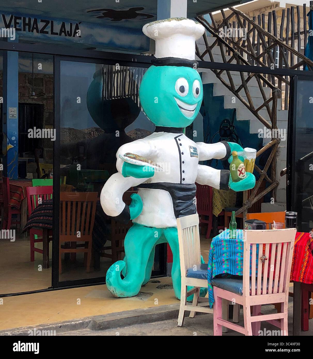 A cheerful octopus waiter statue greets diners outside a beachside restaurant in Progreso, Mexico — serving up seafood and cerveza with a smile! Stock Photo