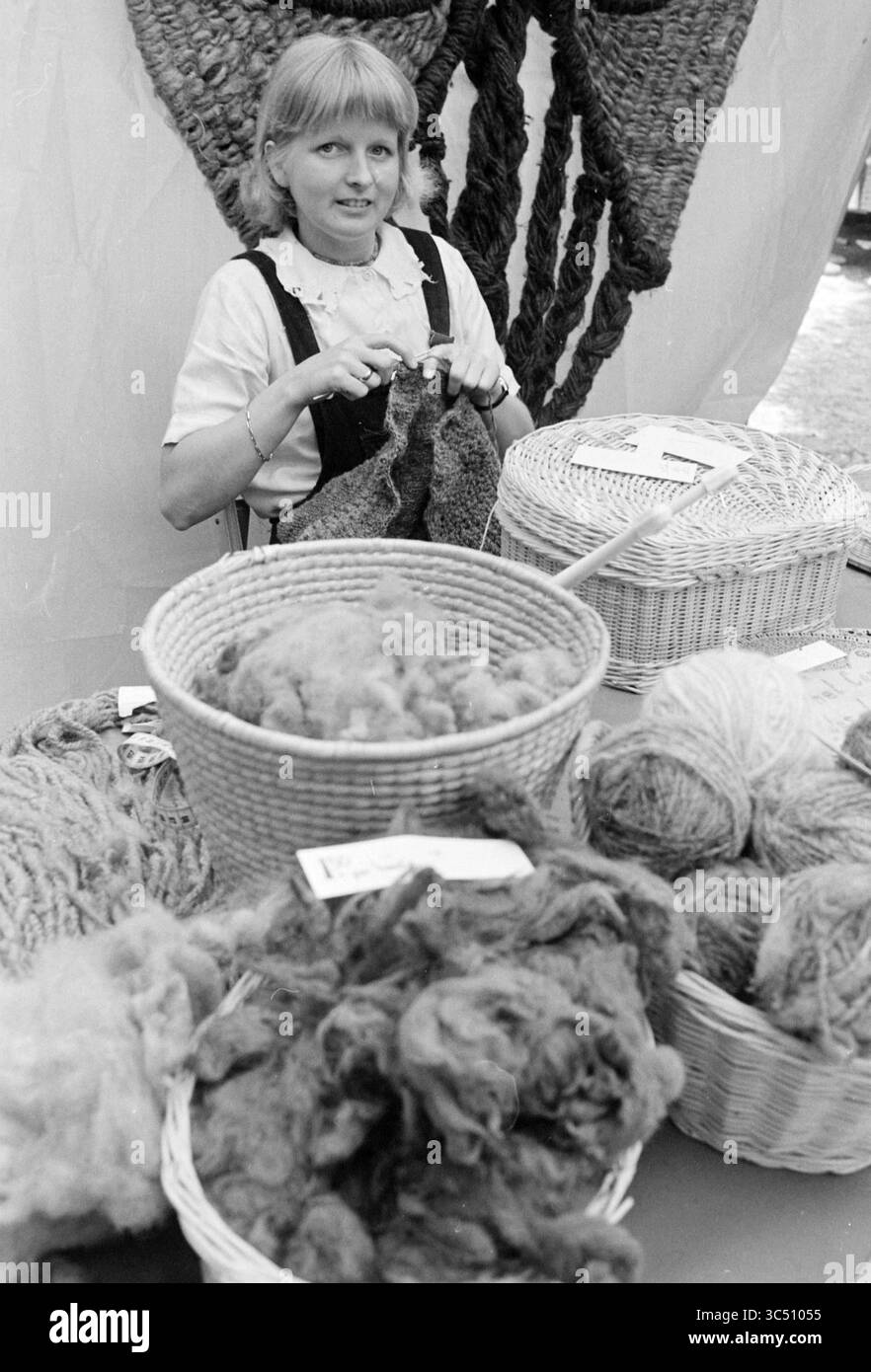 Art market Prinsenhof and antique market Begijnhof, Markt, Haarlem, Begijnhof, The Netherlands, 09-06-1979 Whizgle News, Dutch Desk, The Netherlands, 1950-2000 A woman sits at a crafting booth, skillfully knitting while surrounded by baskets filled with various types of yarn and raw fibers, showcasing her artisan work and dedication to traditional textile arts. Stock Photo
