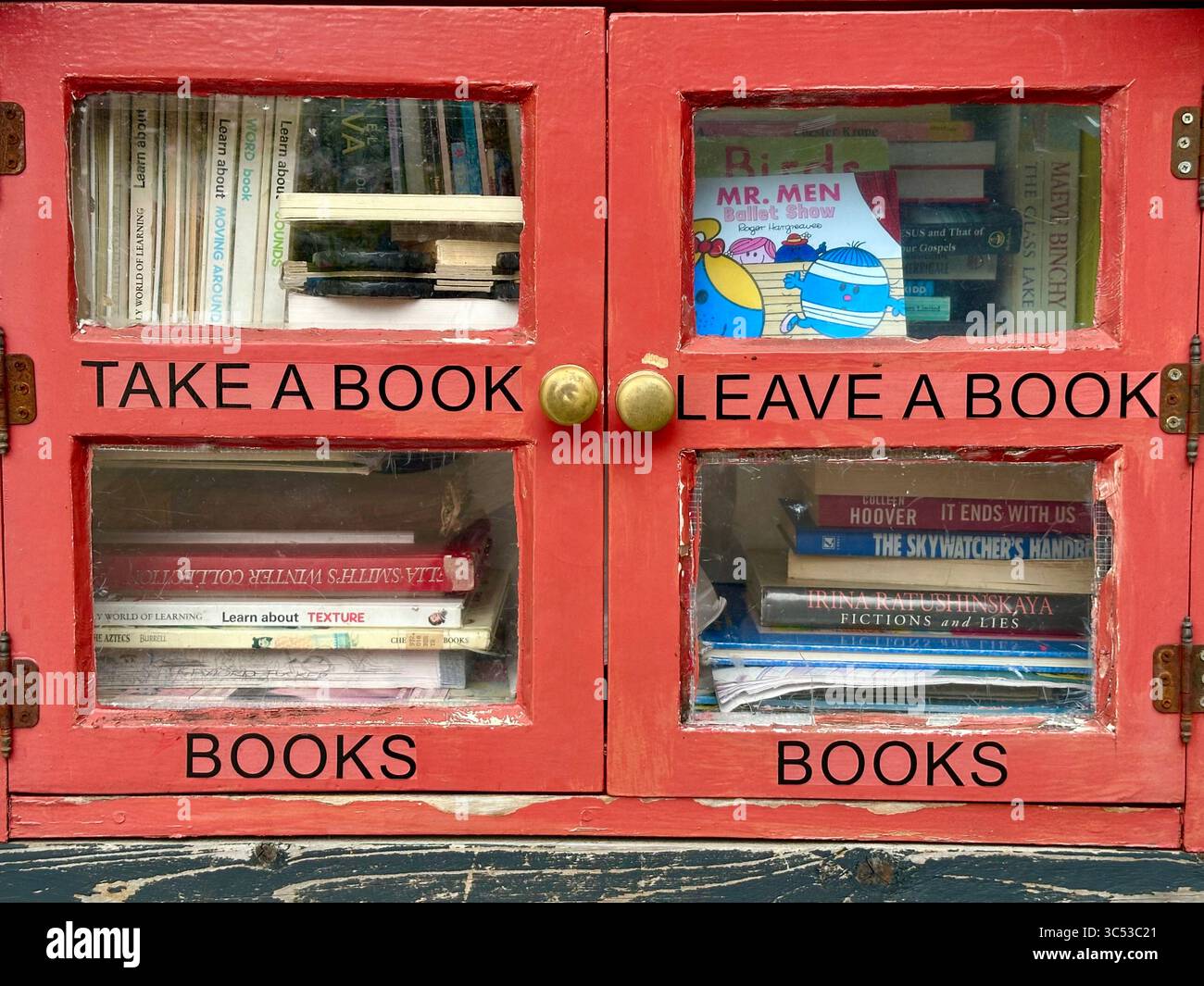 Take a book leave a book little red library in Lewisham, London, England - Smartphone Captured Stock Image