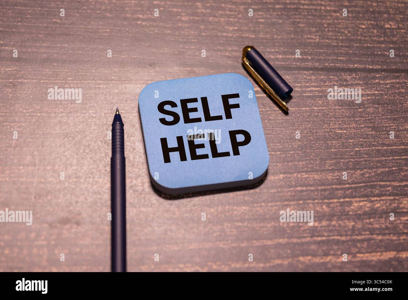 Man putting a card with text self help in the pocket Stock Photo