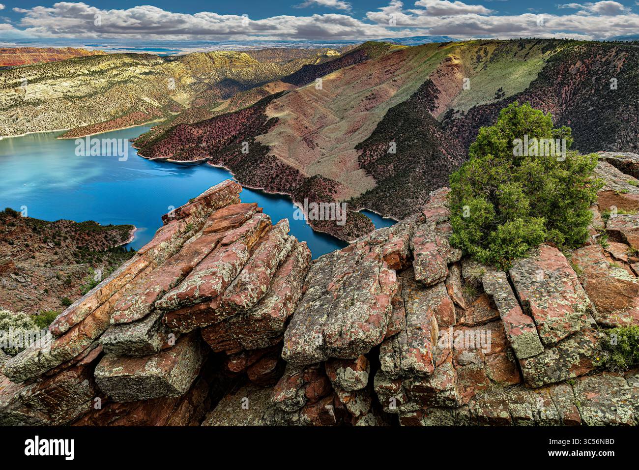 Vividly Banded Sedimentary Rock rises above the Blue Waters of Flaming ...