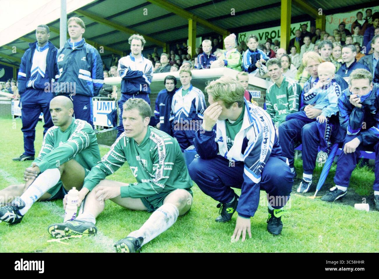 Football, Fulmars - Quick, 05-06-1999 Whizgle News, Dutch Desk, The Netherlands, 1950-2000 A group of soccer players and coaches sit together on the sidelines, displaying a range of emotions as they watch the game unfold. Some are focused and serious, while others appear anxious or contemplative, all under the watchful gaze of an engaged crowd in the background. Stock Photo