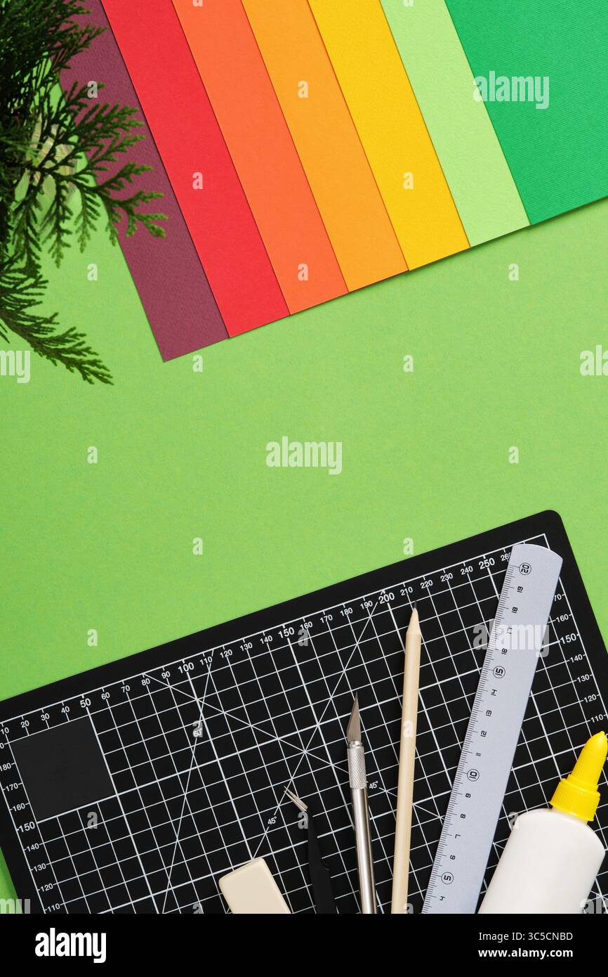 Top view of a desk for paper crafts. Black cutting mat, craft knife ...