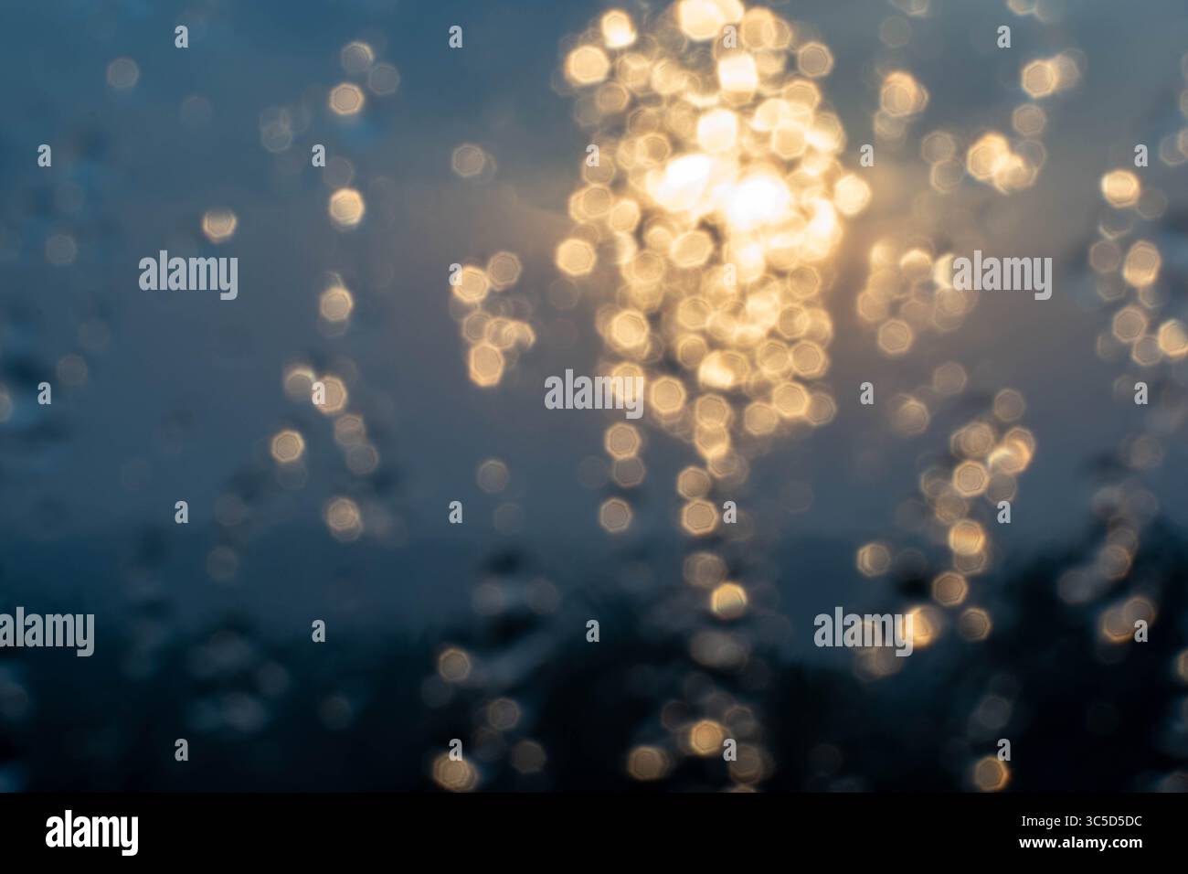Golden light refracts through water, creating a mesmerizing abstract pattern. Stock Photo