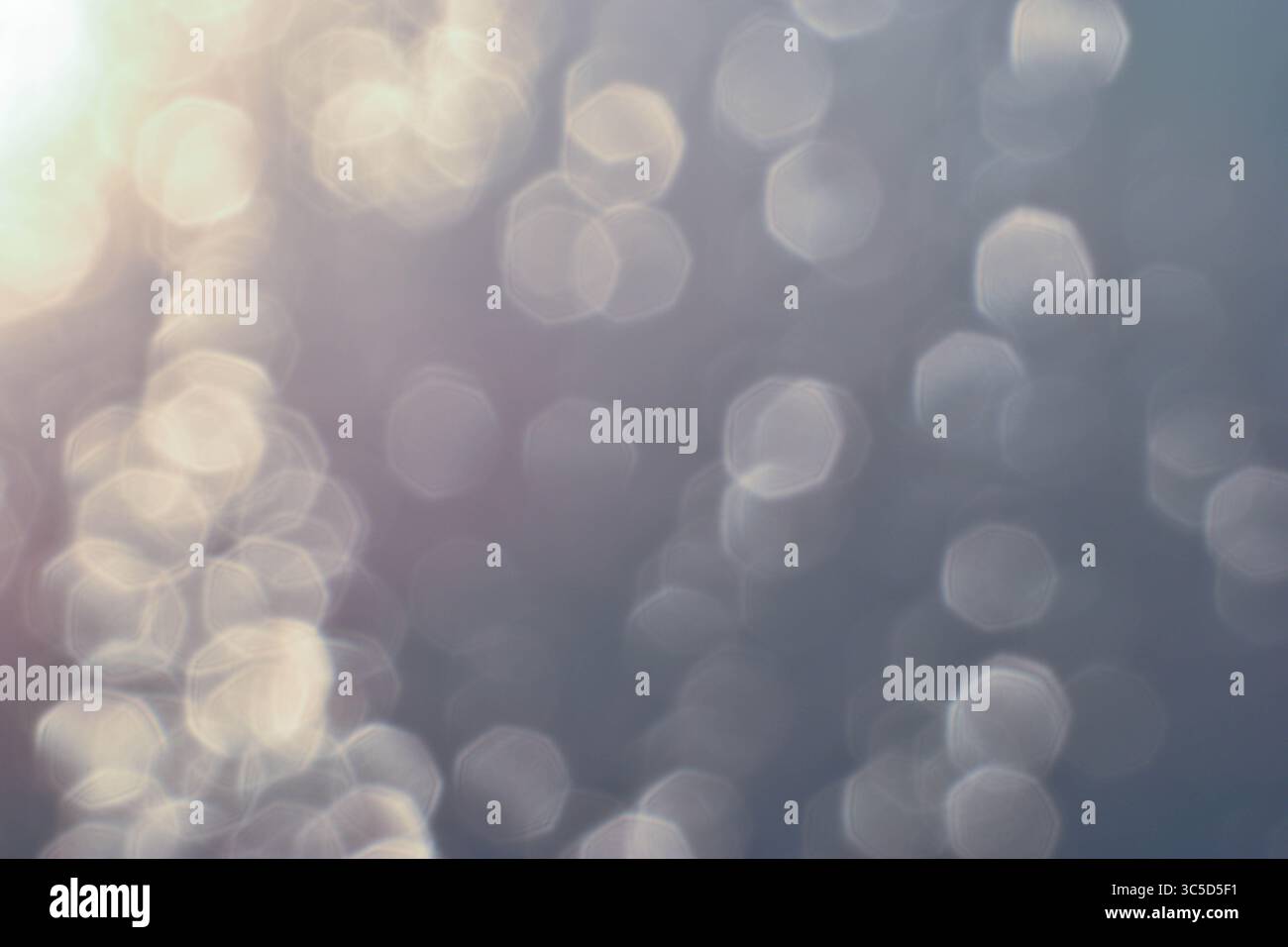 Golden light refracts through water, creating a mesmerizing abstract pattern. Lighting, Bokeh Stock Photo