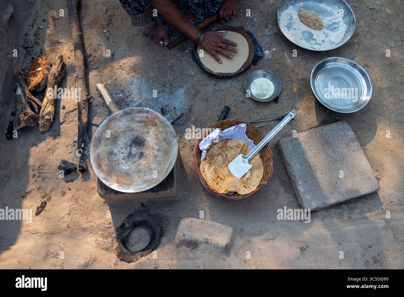 A village woman makes bread on the stove. cooking bread in clay stove ...