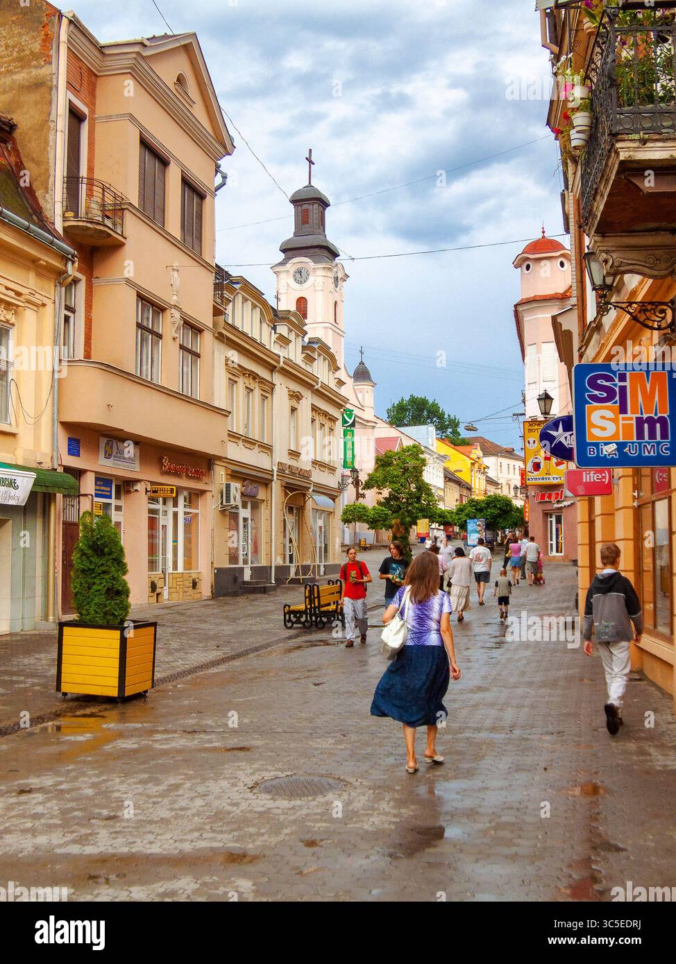 uzhhorod, ukraine - 01 jul, 2007: city after the rain with wet street. beautiful architecture of the historic center. water on the sidewalk. urban lan Stock Photo