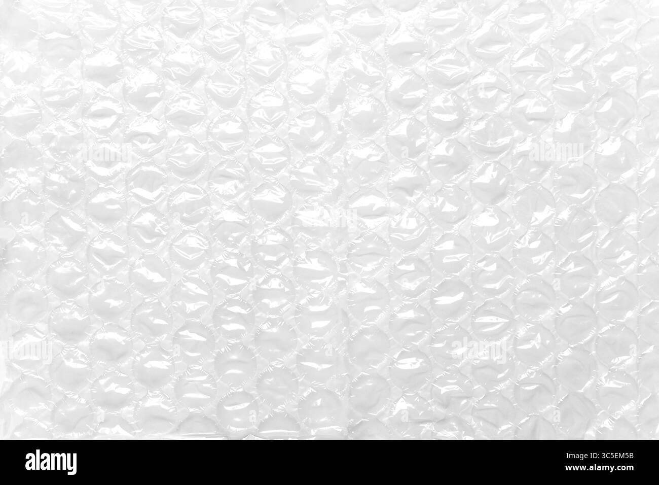 Transparent packaging bubble wrap on white table. Abstract background. Soft protective material Stock Photo