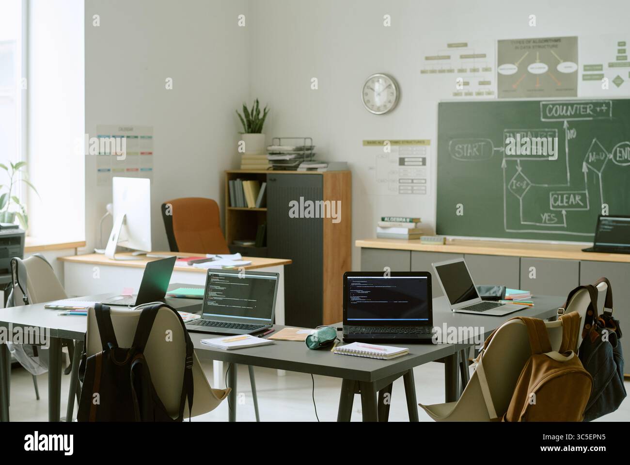 Empty Classroom with Laptops Displaying Programming Code during School Lesson Stock Photo