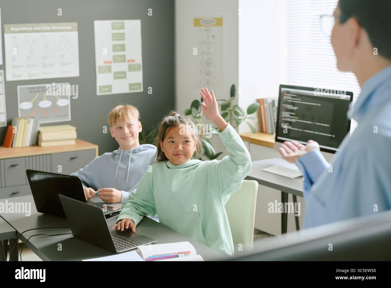 Asian Girl and Caucasian Boy Using Laptops While Participating in Coding Class Stock Photo