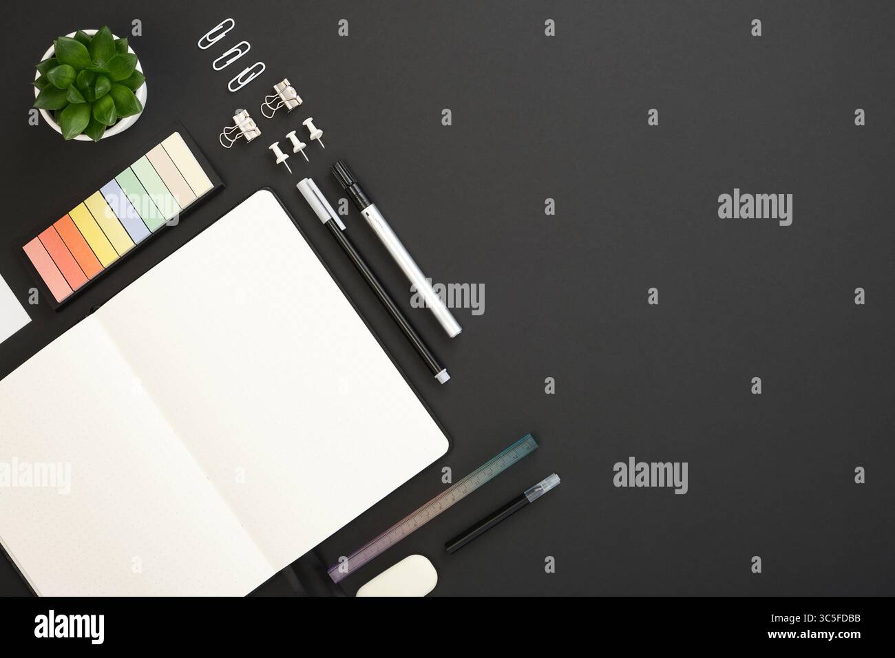 Card with black, white and gray school and office stationery and note on black background. Flatly, copyspace. Stock Photo